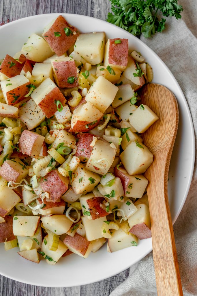 Bowl of potato salad with wooden spoon