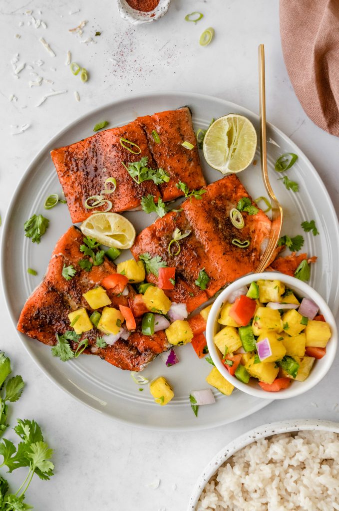3 salmon filets with a bowl of pineapple salsa