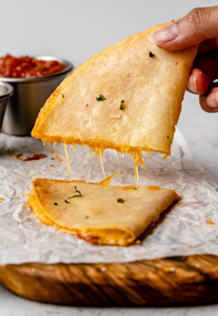 Pulling a cheese quesadilla in half.