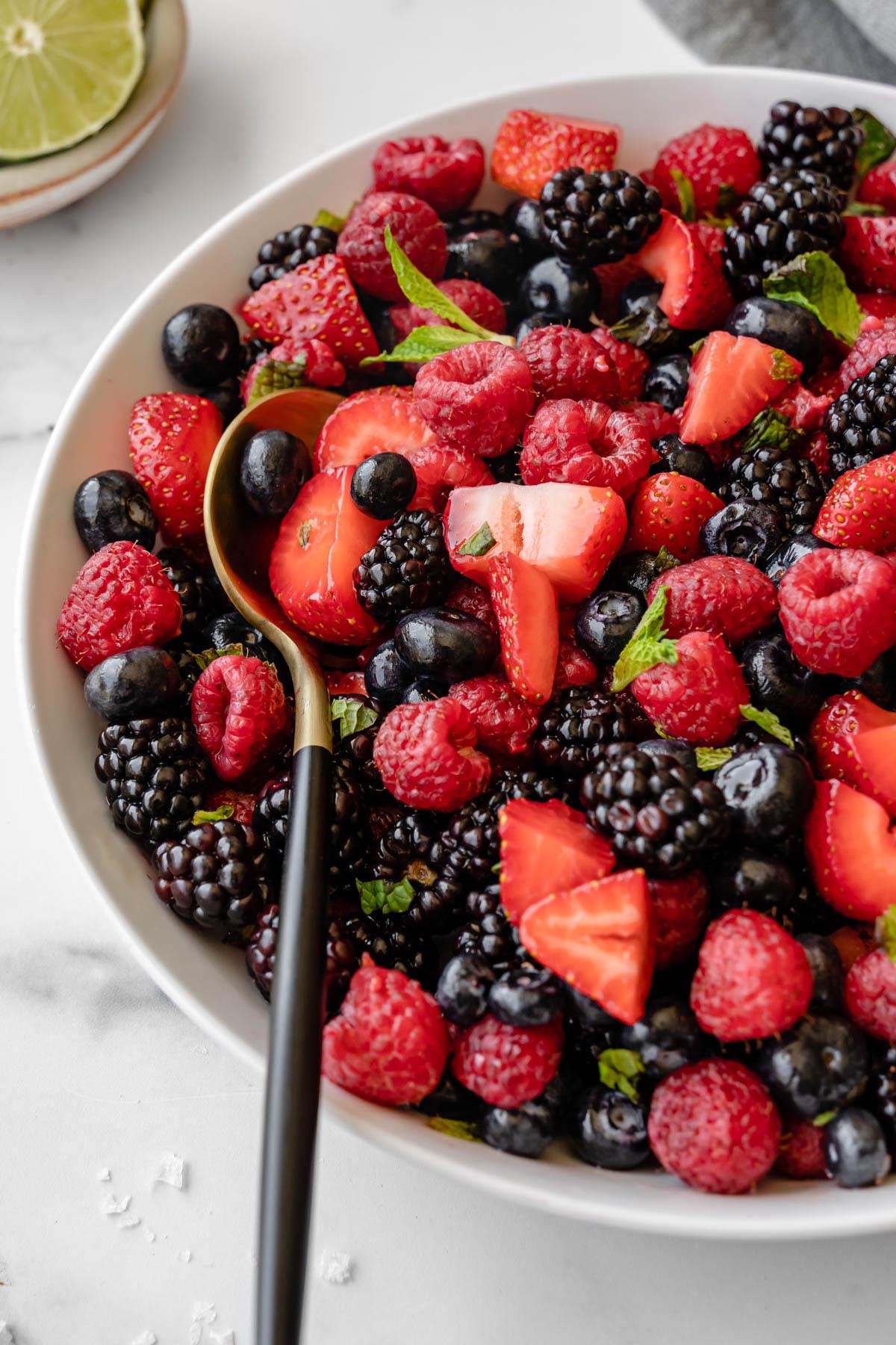 Closeup of berry salad in a white bowl.
