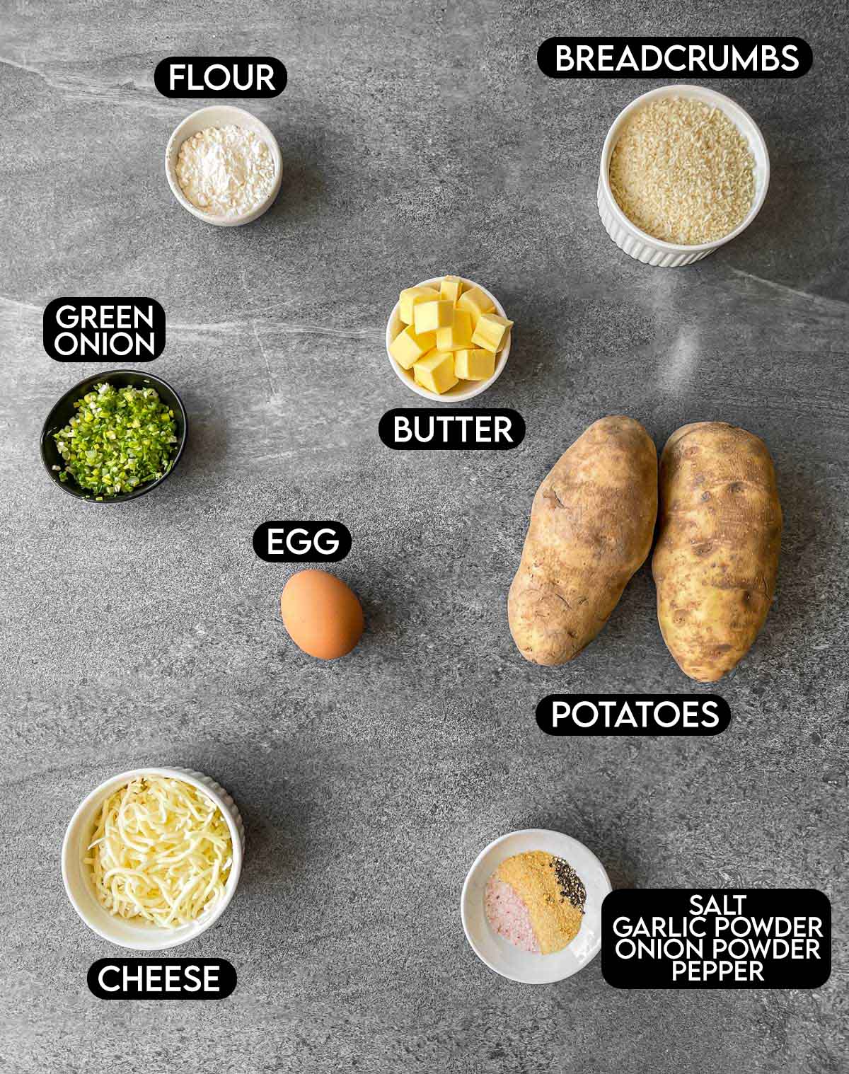 Labeled ingredients for potato croquettes: flour, breadcrumbs, green onion, butter, egg, potatoes, cheese, salt, garlic powder, onion powder, and pepper.