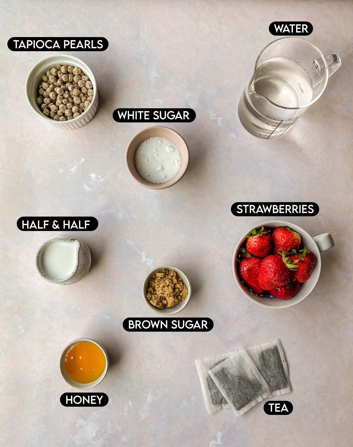 Labeled ingredients for strawberry milk tea: tapioca pearls, white sugar, water, half & half, strawberries, brown sugar, honey, & tea.