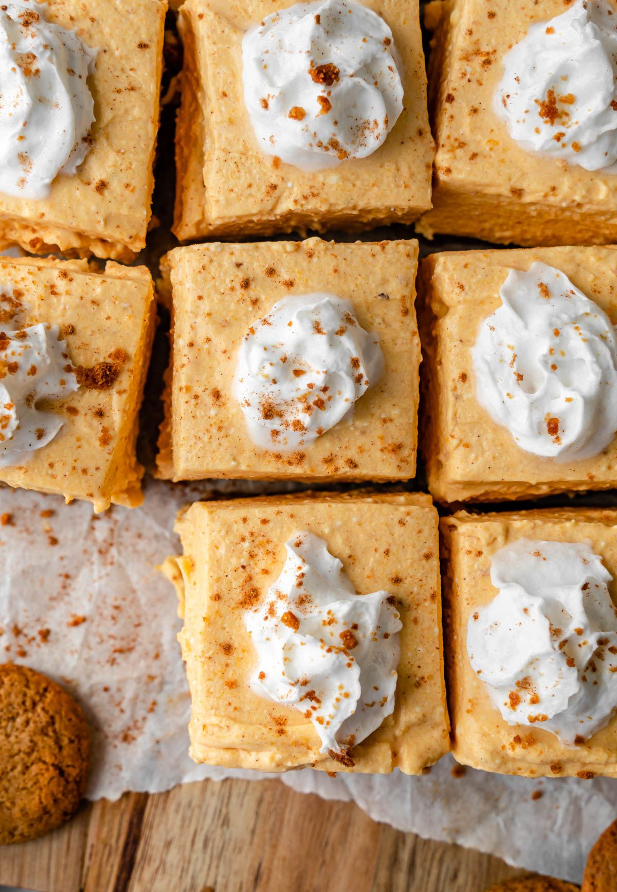 Close up of 5 pumpkin cheesecake bars with a cookie to the side.