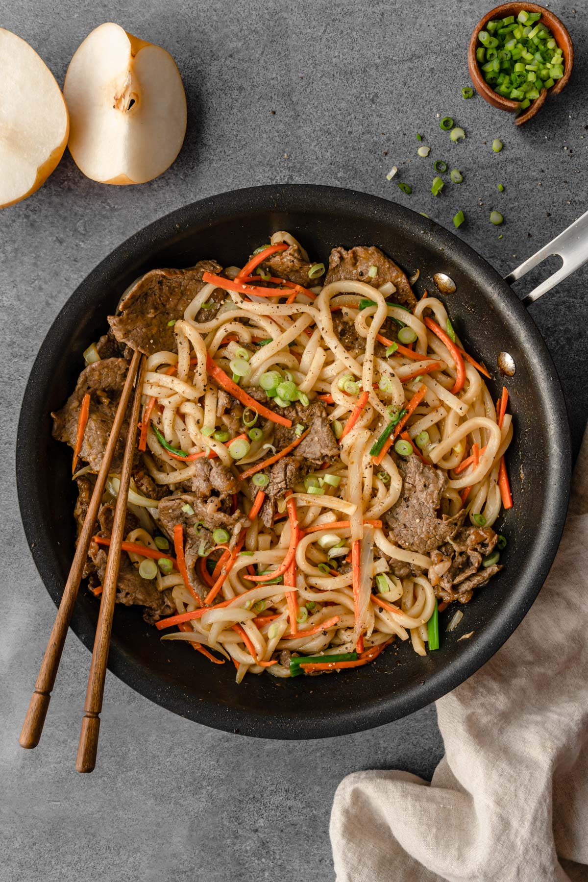 A skillet of Bulgogi Beef Udon with chopsticks in it.