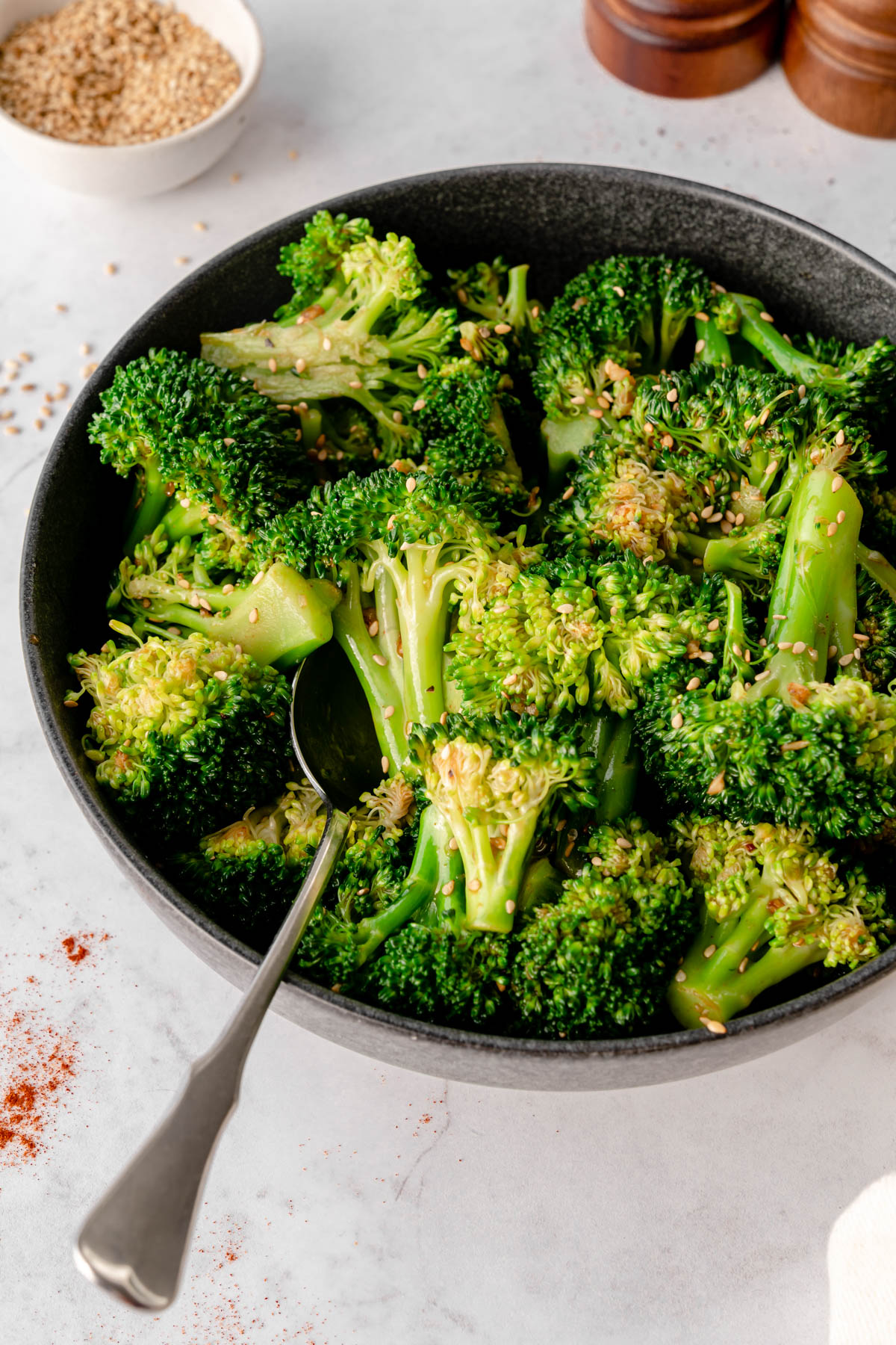 Close up of Korean Broccoli Salad in a black bowl with a spoon in it.